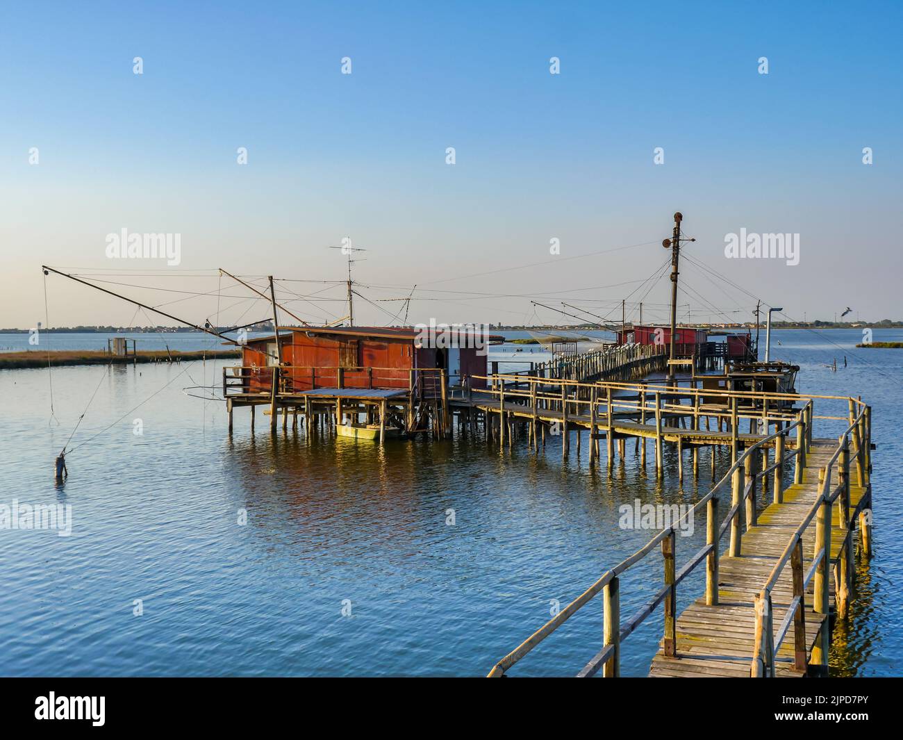 Fishing pier on a tropical beach with fishing nets and hut Stock Photo -  Alamy