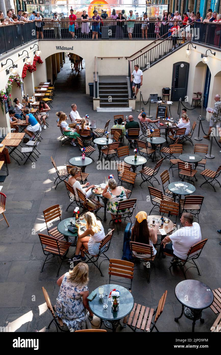 People Sitting Down At A Cafe/Restaurant In The Piazza In Covent Garden, London, UK Stock Photo