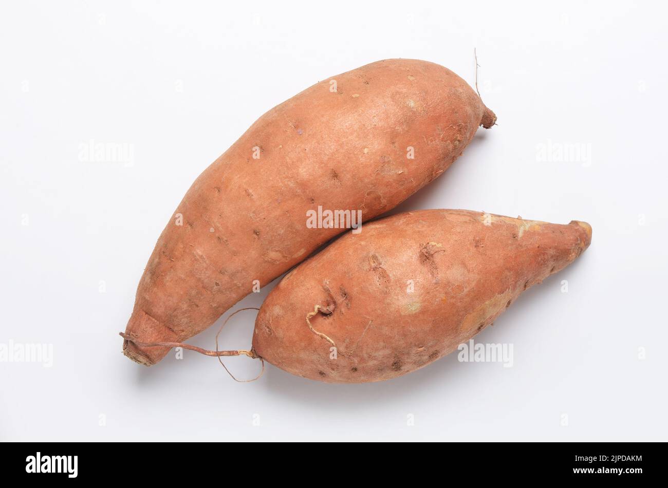 Two sweet potatoes Ipomoea batatas shot from directly above on white background Stock Photo