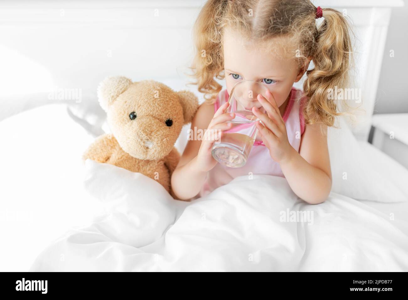 The child is drinking water in the bed Stock Photo Alamy
