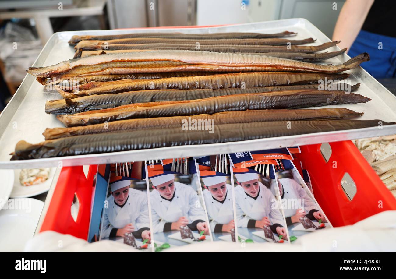 Maasholm, Germany. 17th Aug, 2022. Fresh smoked eel lies on a tray in the harbor of Maasholm during the '13th Aalutsetten in de Schlie'. The Schleifischer released around 108,000 young eels into the Schlei during the traditional 13th 'Aalutsetten' on Wednesday. Credit: Christian Charisius/dpa/Alamy Live News Stock Photo