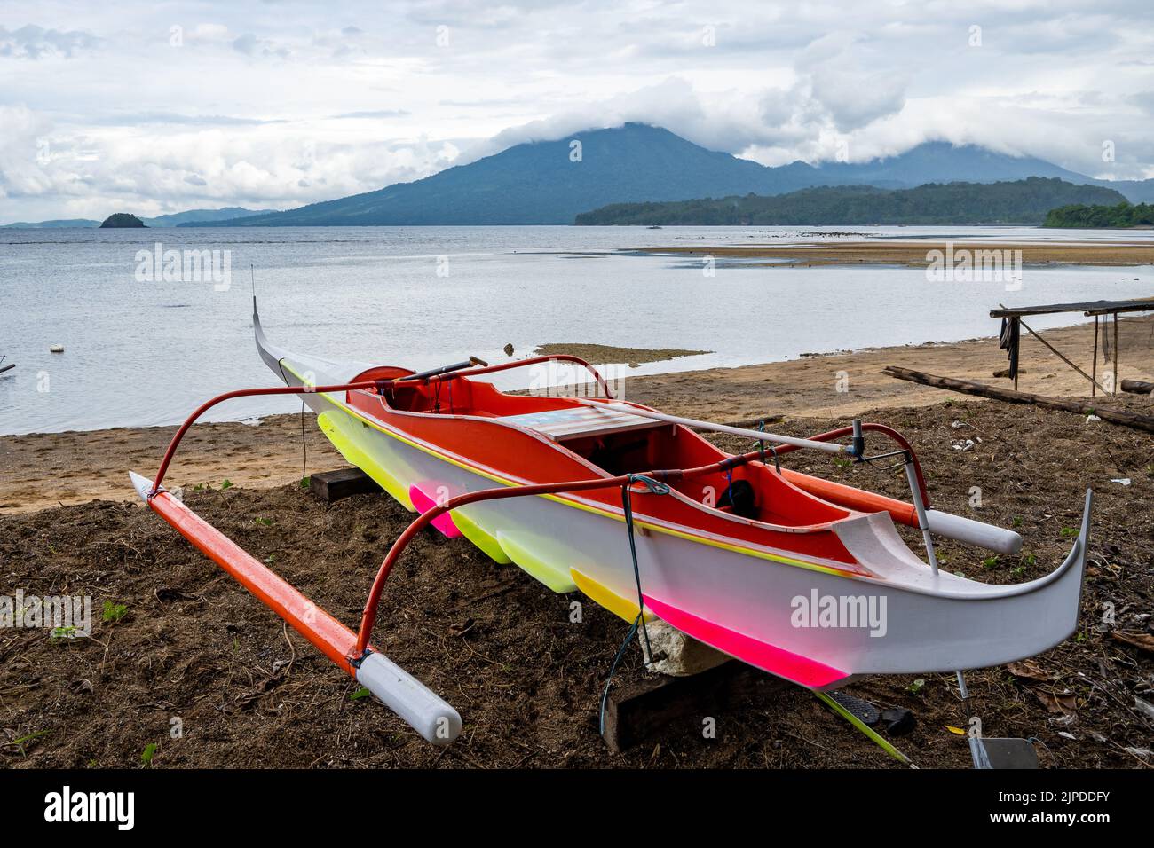 A colorfully painted outrigger canoe on the beach. Sulawesi, Indonesia. Stock Photo