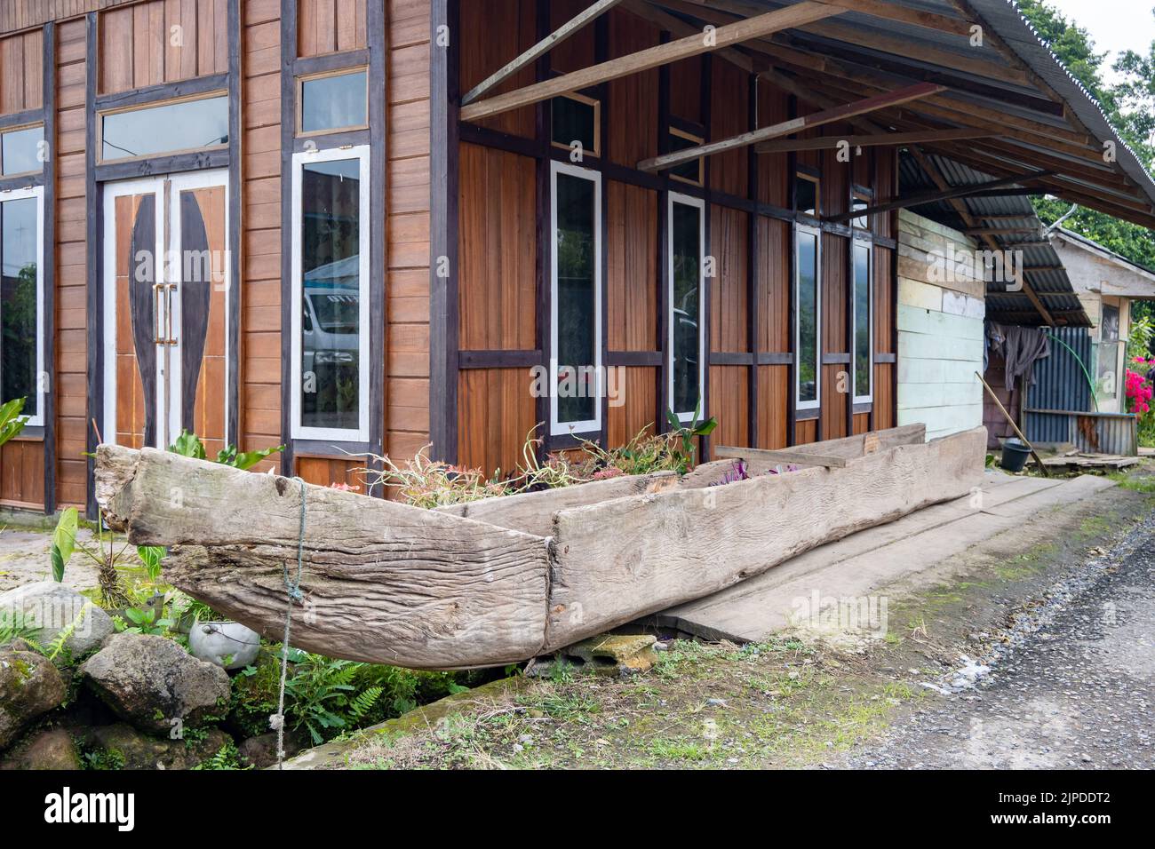 A traditional dugout canoe in front of a house. Sulawesi, Indonesia. Stock Photo