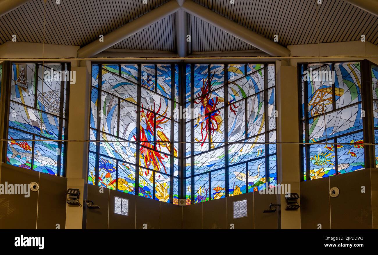 Colorful painted glass window inside the terminal of Manado airport. Sulawesi, Indonesia. Stock Photo