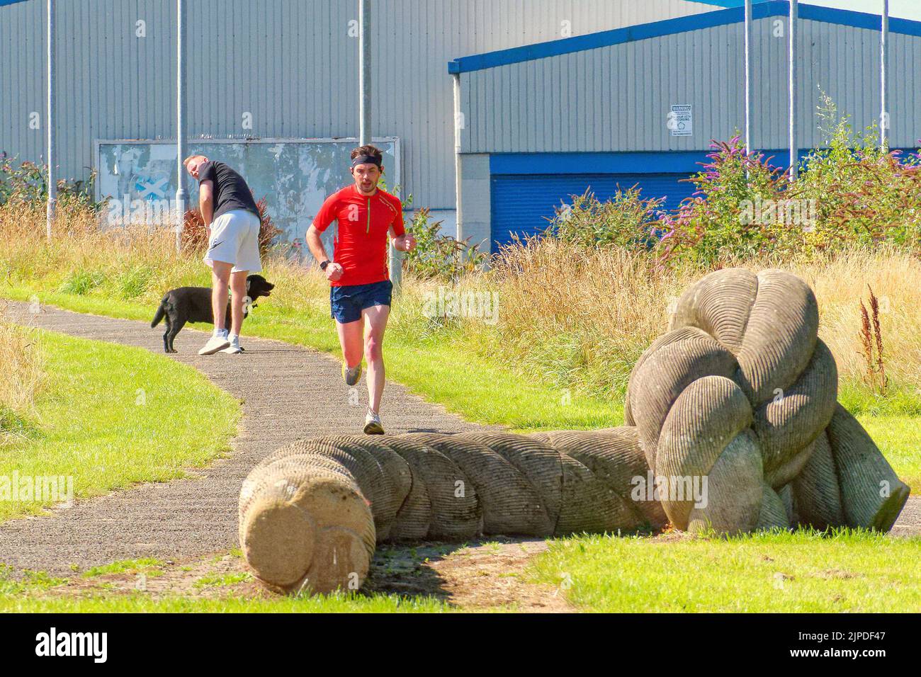 Glasgow, Scotland, UK  17th August,  2022. UK Weather:  Sunny on the forth and clyde canal as locals take to the towpath..  The rope sculpture that celebrates the towpath being used to pull boats, by rope.Credit Gerard Ferry/Alamy Live News Stock Photo