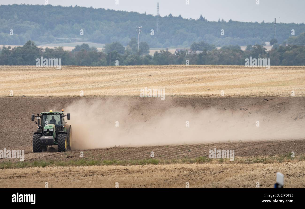 Echzell, Germany. 17th Aug, 2022. A farmer works his field after the harvest, dragging a cloud of dust behind him. After months of drought, the weather in Hesse is expected to become increasingly changeable in the coming days. Credit: Frank Rumpenhorst/dpa/Alamy Live News Stock Photo