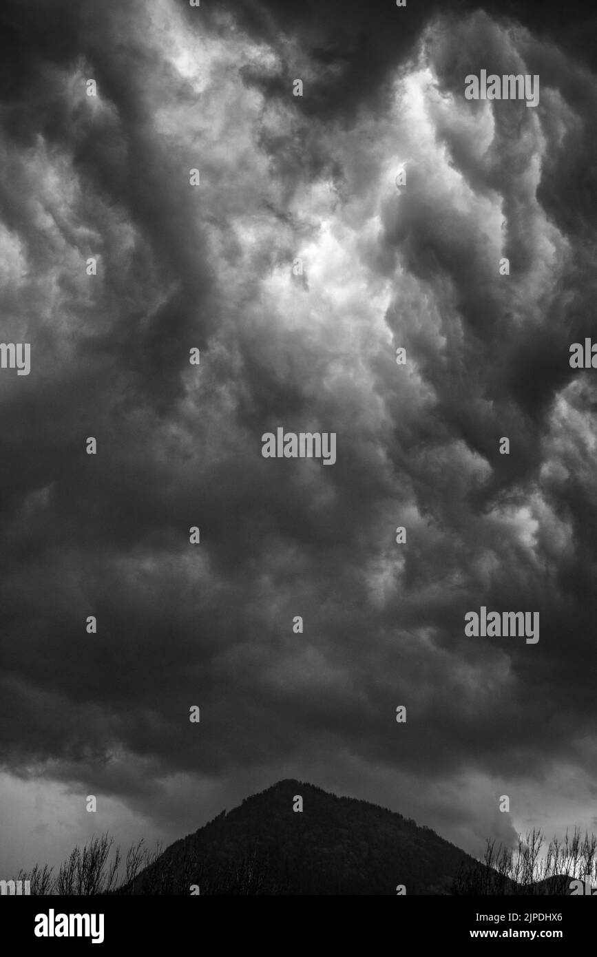 Cloudy stormy black and white dramatic sky background over hill Stock Photo