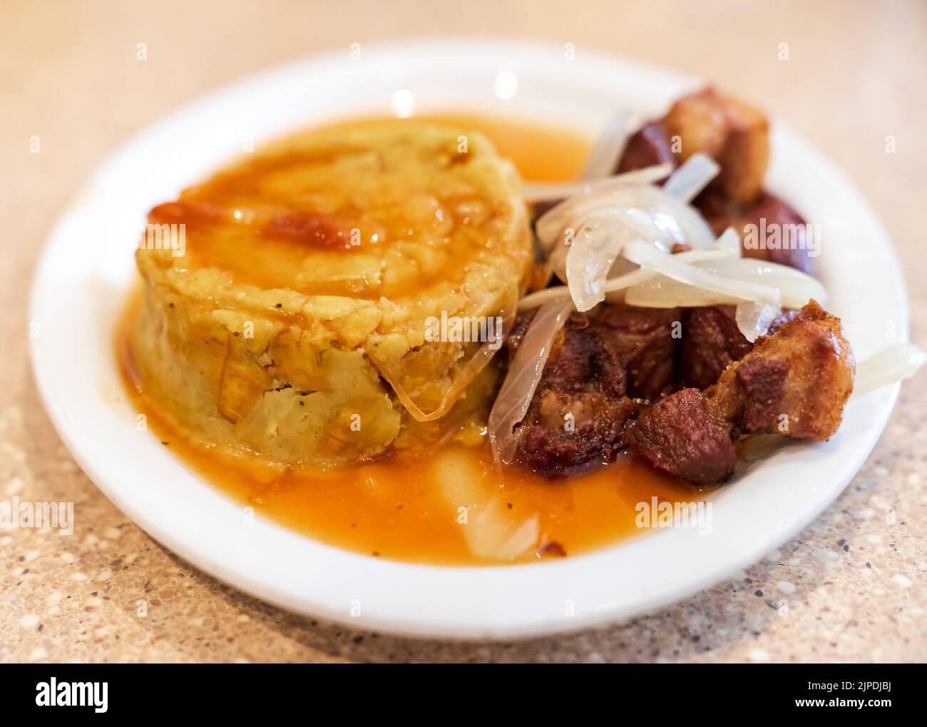 Delicious Puerto Rican Fried Pork Mofongo with Onions and Garlic Sauce. Stock Photo