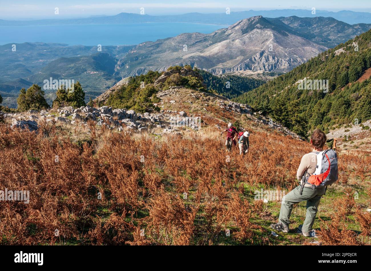A walker looks down on the Outer Mani coast towards Kalamata and across the Gulf of Messini, from Niva hill above Voria, in the Taygetos mountains, So Stock Photo