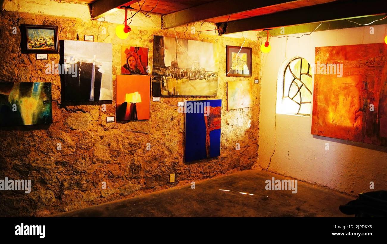 small room with display of student artwork, with wiring and cracked walls, metal beams and wood staves Stock Photo
