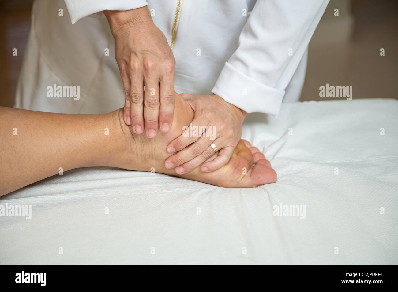 Goiânia, Goias, Brazil – July 18, 2022: Closeup of massage therapist hands applying therapeutic massage to a patient's foot. Stock Photo