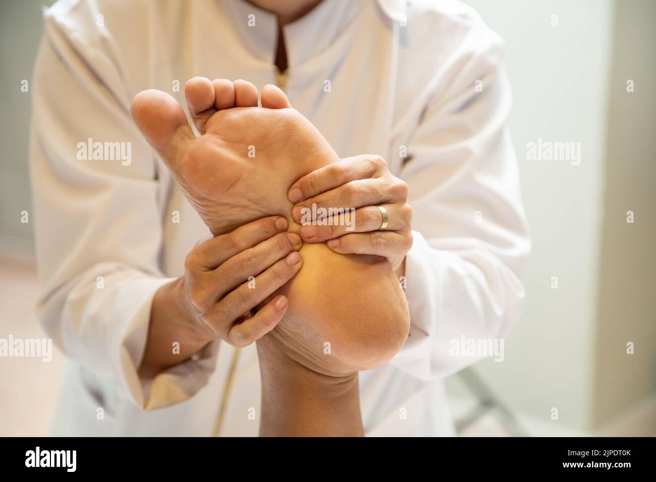 Goiânia, Goias, Brazil – July 18, 2022: Closeup of massage therapist hands applying therapeutic massage to a patient's foot. Stock Photo