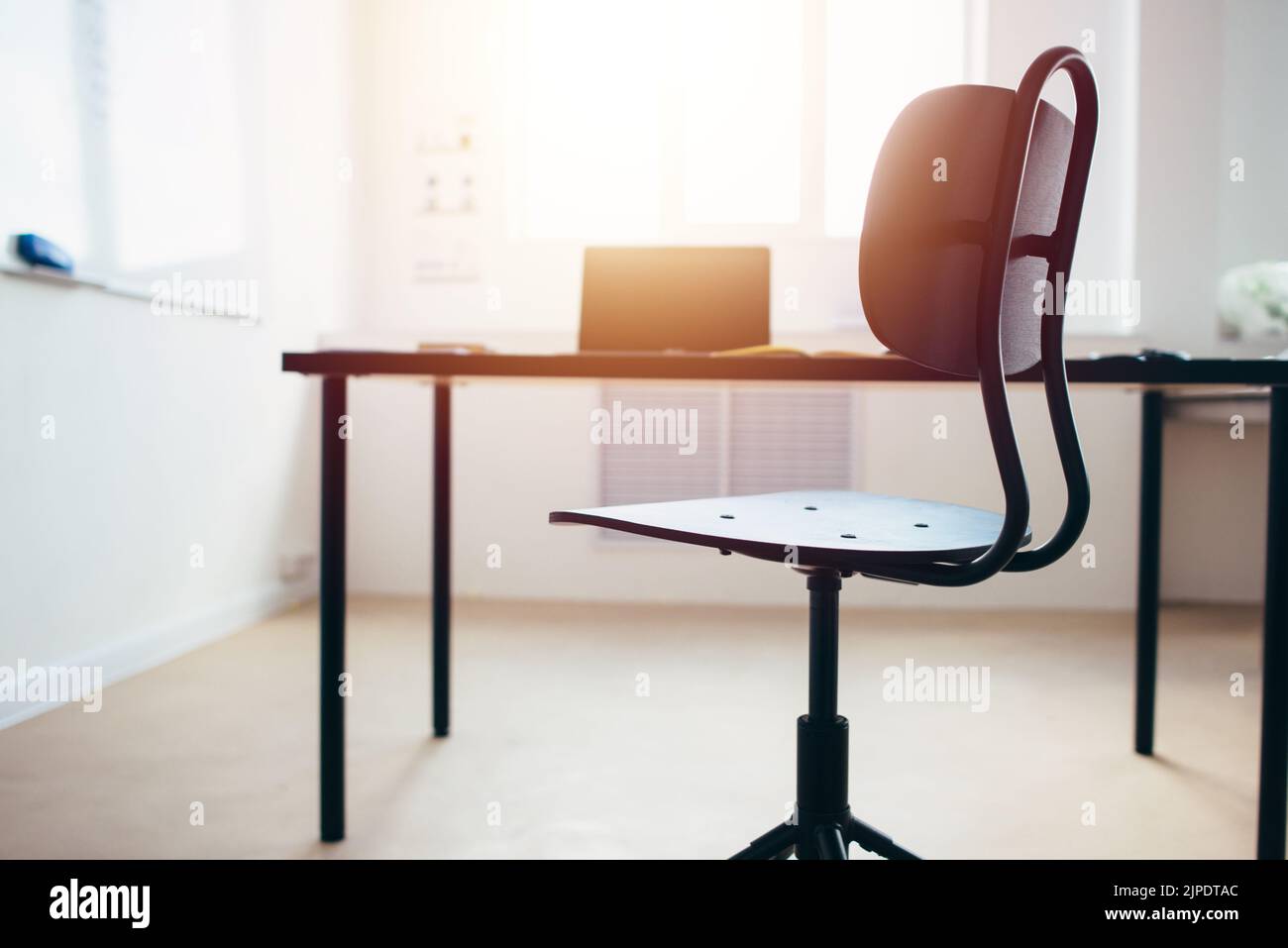 Empty work space chair, desk with laptop. Stock Photo