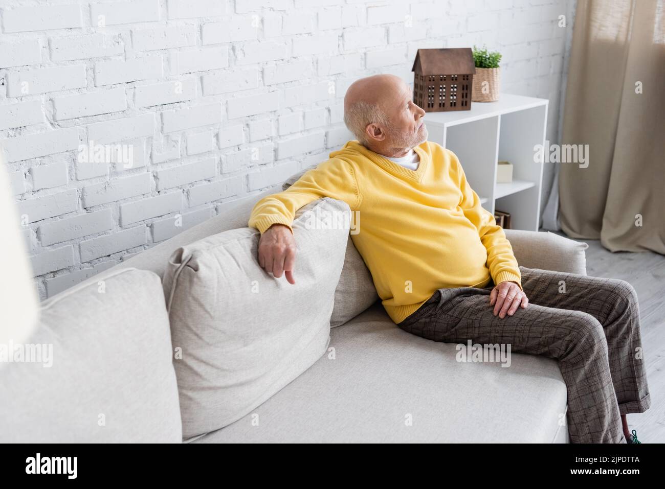 Elderly man sitting on couch hi-res stock photography and images - Alamy