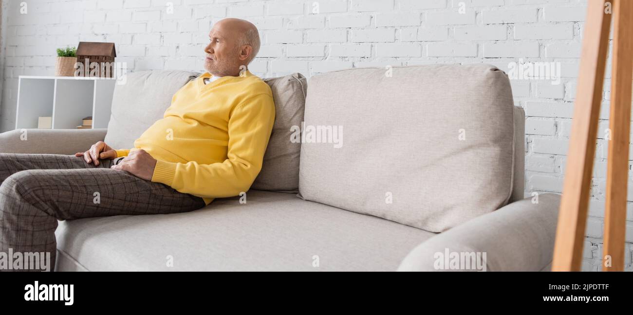 Sad senior man sitting on couch hi-res stock photography and images - Alamy