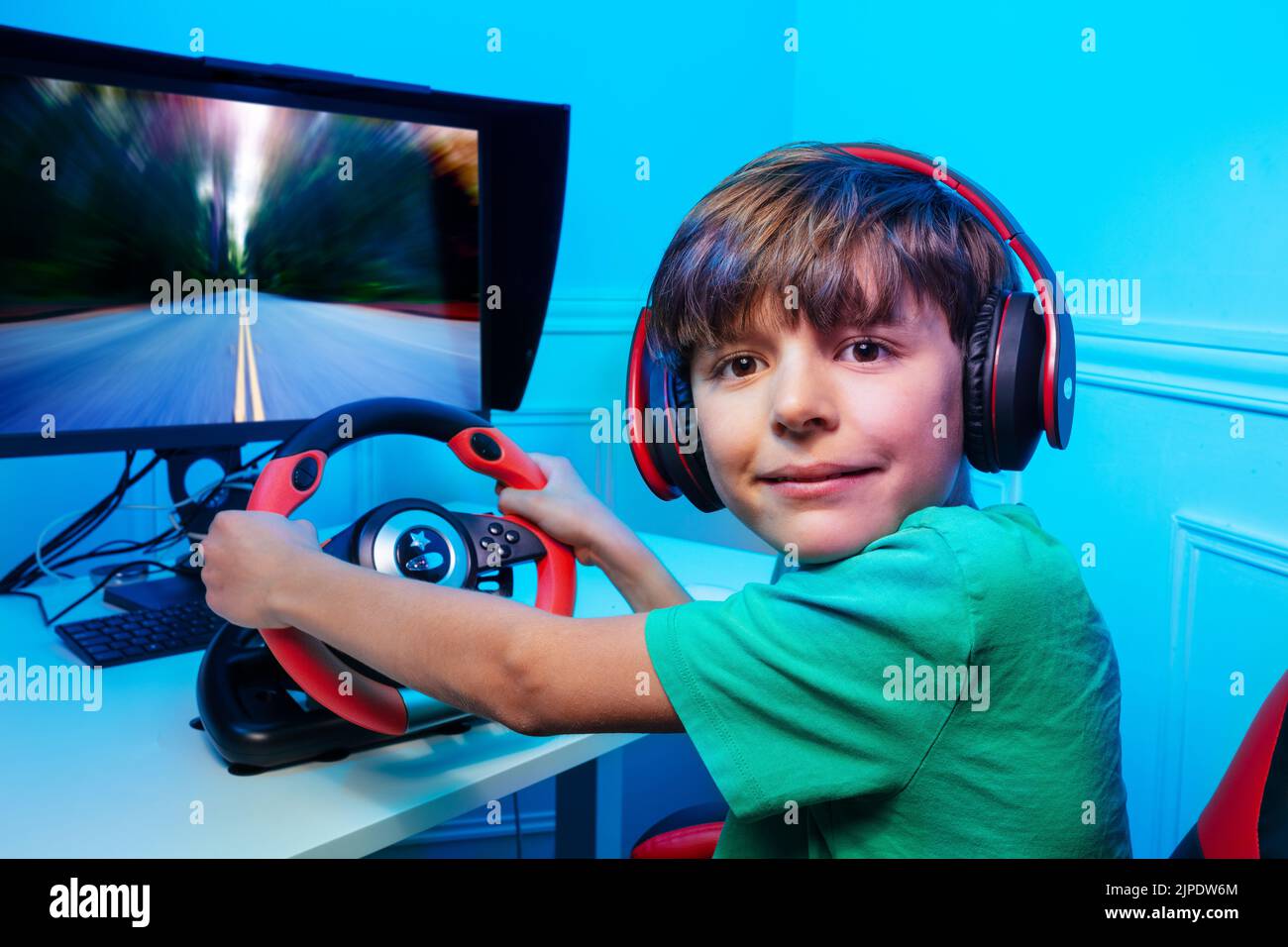 Boy hands on steering wheel play race game turn and look back Stock Photo
