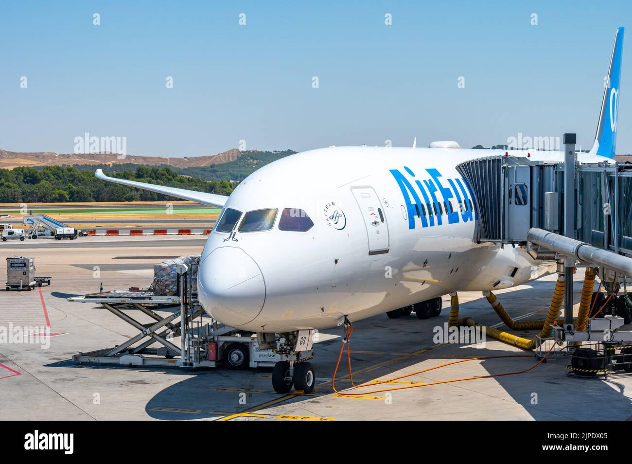 A Passenger Boarding Bridge (PBB) which is also known as an air bridge or jet bridge is attached to an Air Europa plane in a Spanish airport Stock Photo