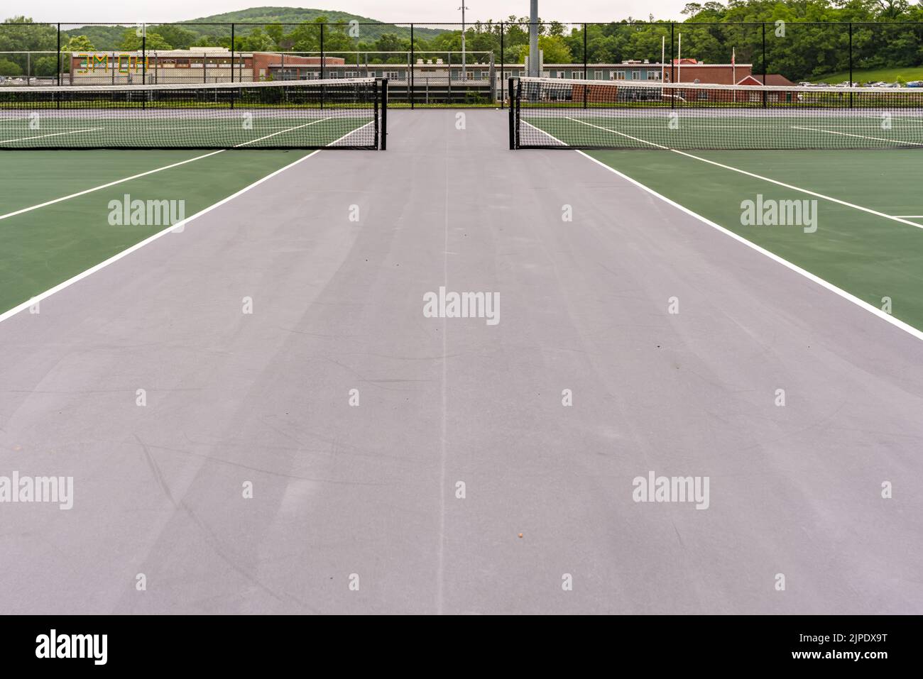 New outdoor green tennis courts with white lines and gray out of bounds