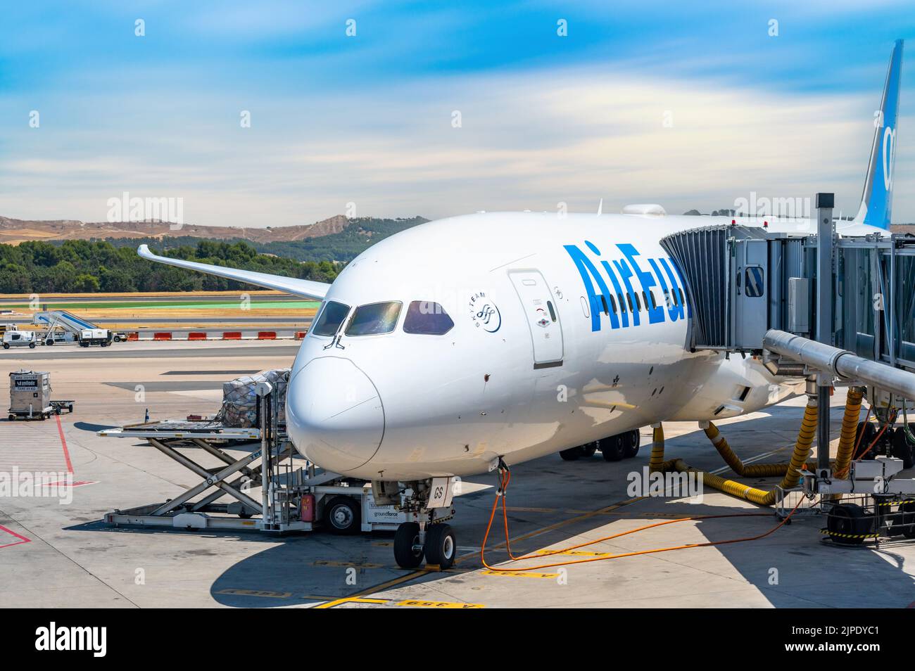 A Passenger Boarding Bridge (PBB) which is also known as an air bridge or jet bridge is attached to an Air Europa plane in a Spanish airport Stock Photo