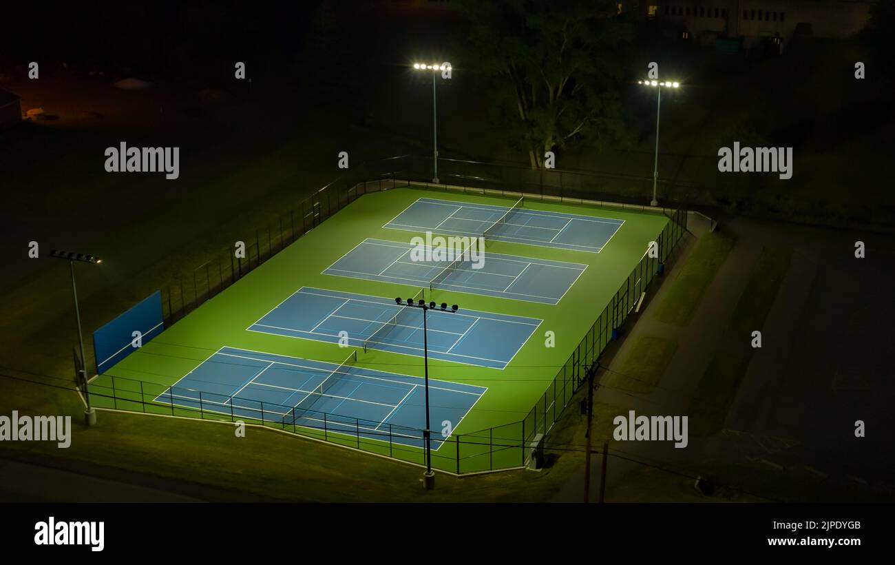 Evening aerial video of outdoor blue tennis courts with pickleball Evening aerial video of outdoor blue tennis courts with pickleball