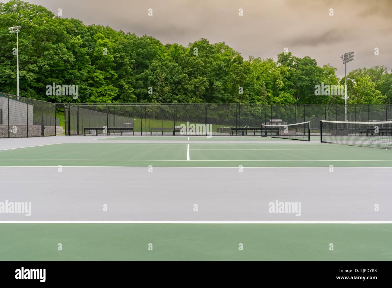 New outdoor green tennis courts with white lines and gray out of bounds