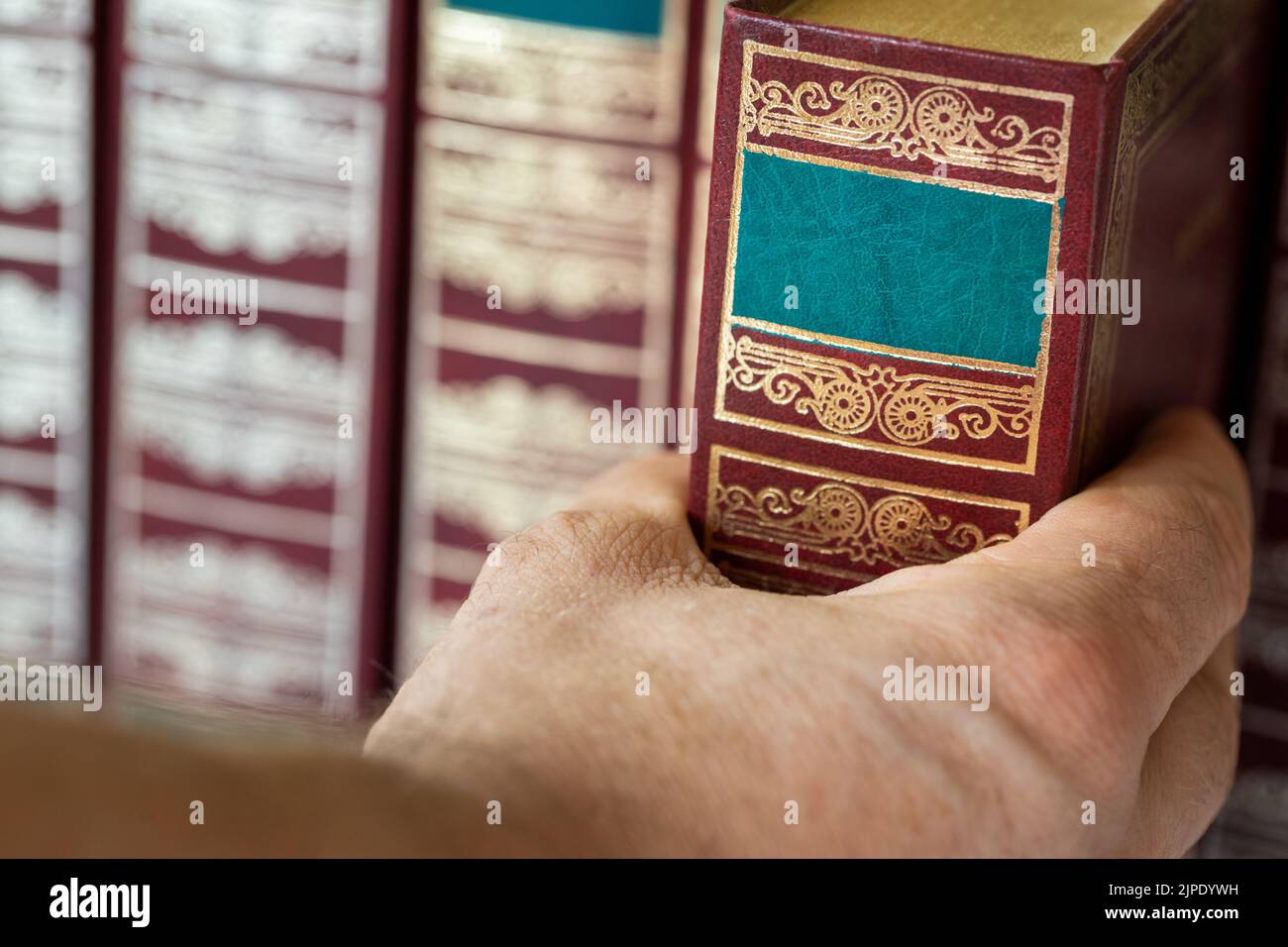 Hand reaching for a book, Stylish books, Classics of literature, close up Stock Photo