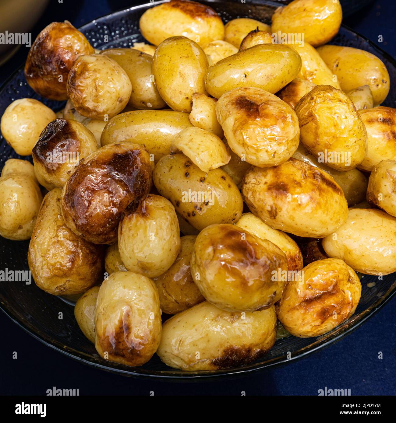 A tray of roasted new potatoes at a barbecue Stock Photo