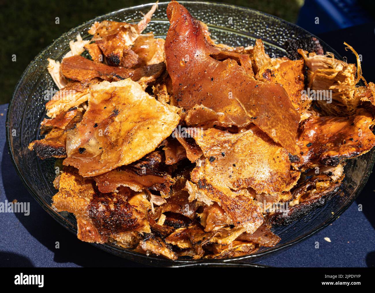 A tray of roasted pork crackling at a hog roast barbecue Stock Photo