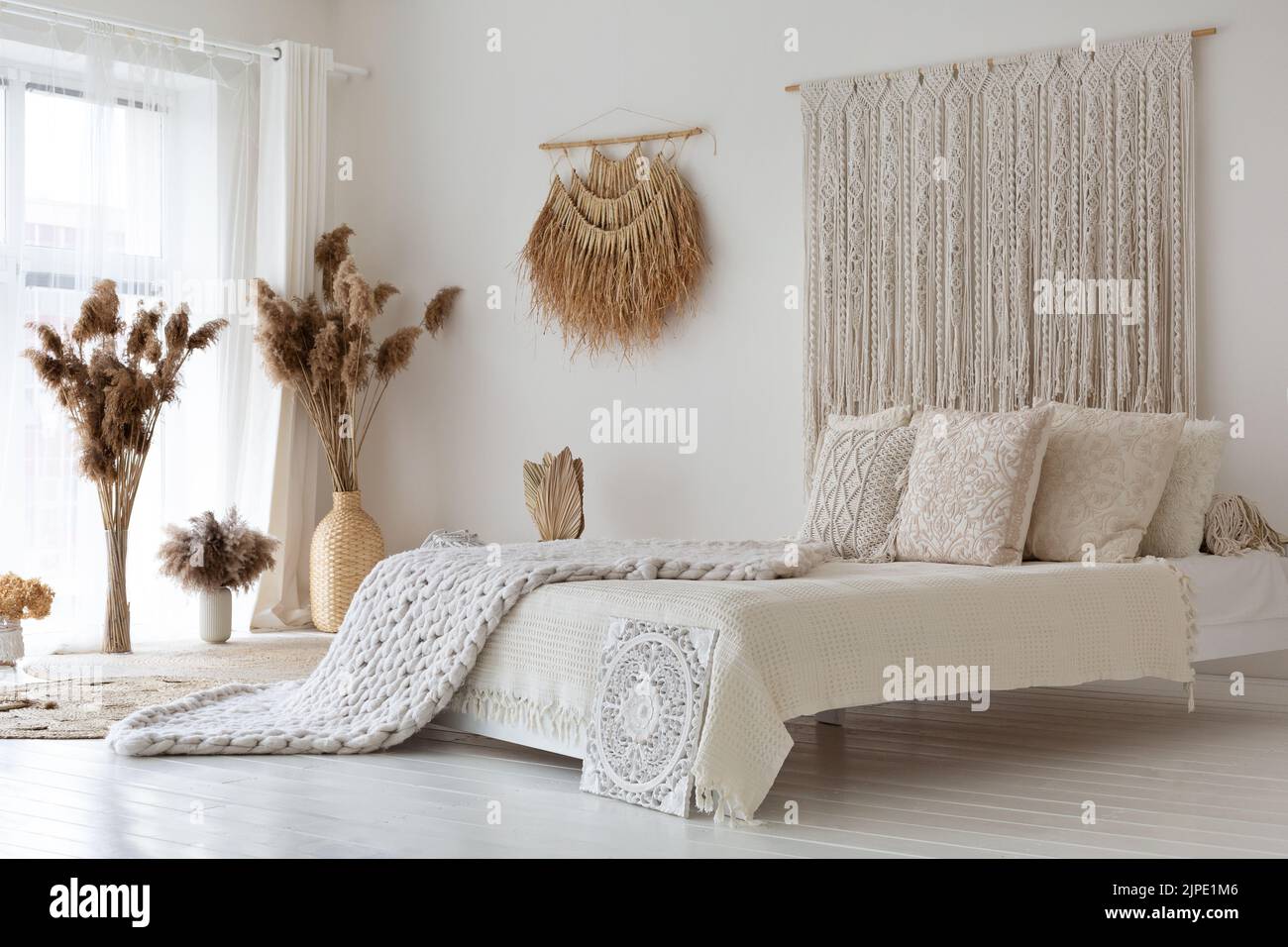 Empty white bedroom made in ethnic style Stock Photo - Alamy