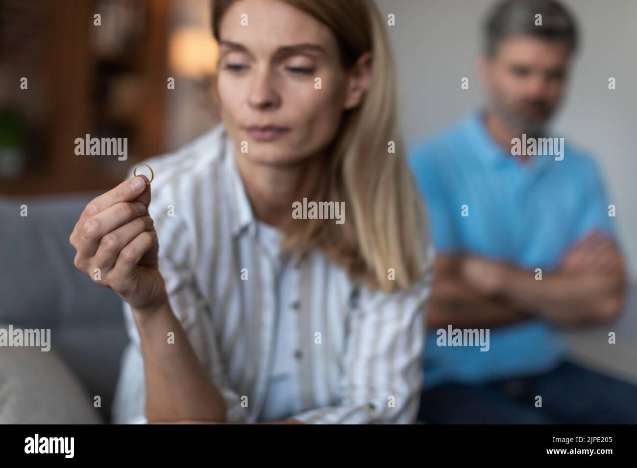 Unhappy sad adult caucasian wife holding ring and ignoring disappointed 