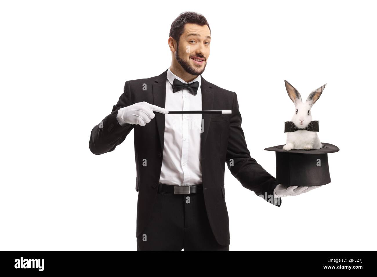 Magician performing a trick with a hat and a rabbit isolated on white background Stock Photo