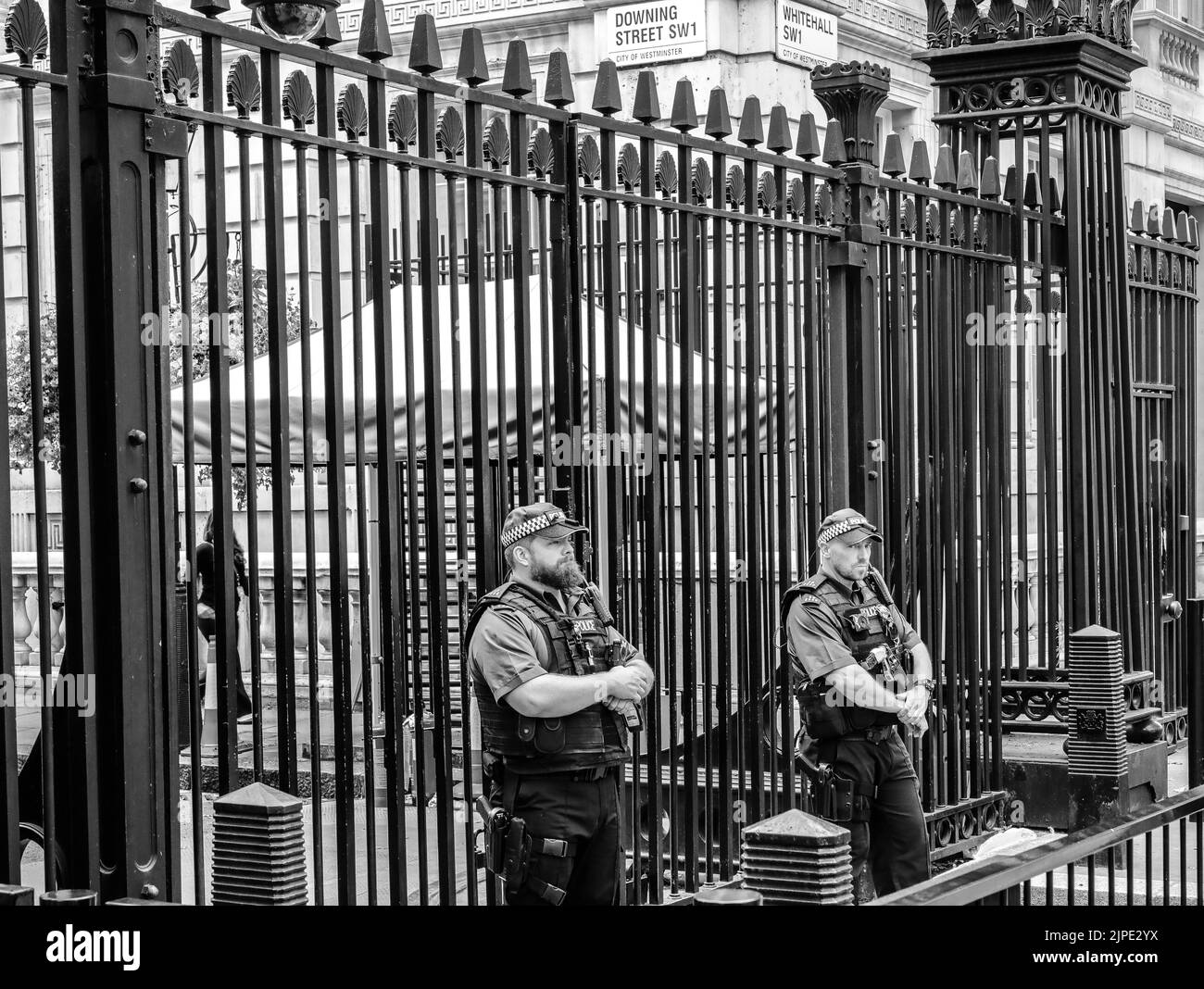 Two policemen stand guard outside the gates to Downing Street in London