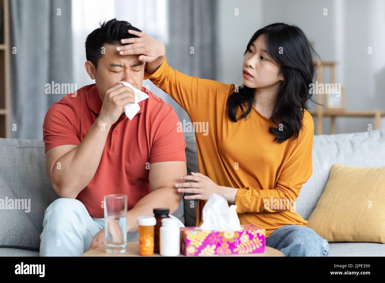 Young wife taking care of sick husband at home Stock Photo