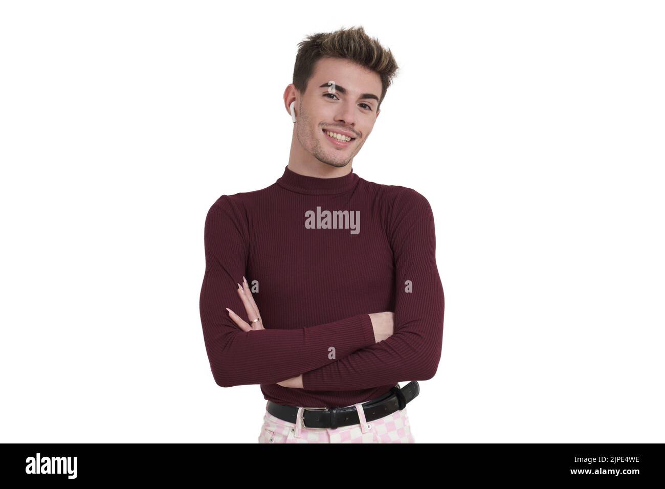 Young caucasian man smiling with his arms crossed and earphones, isolated. Stock Photo