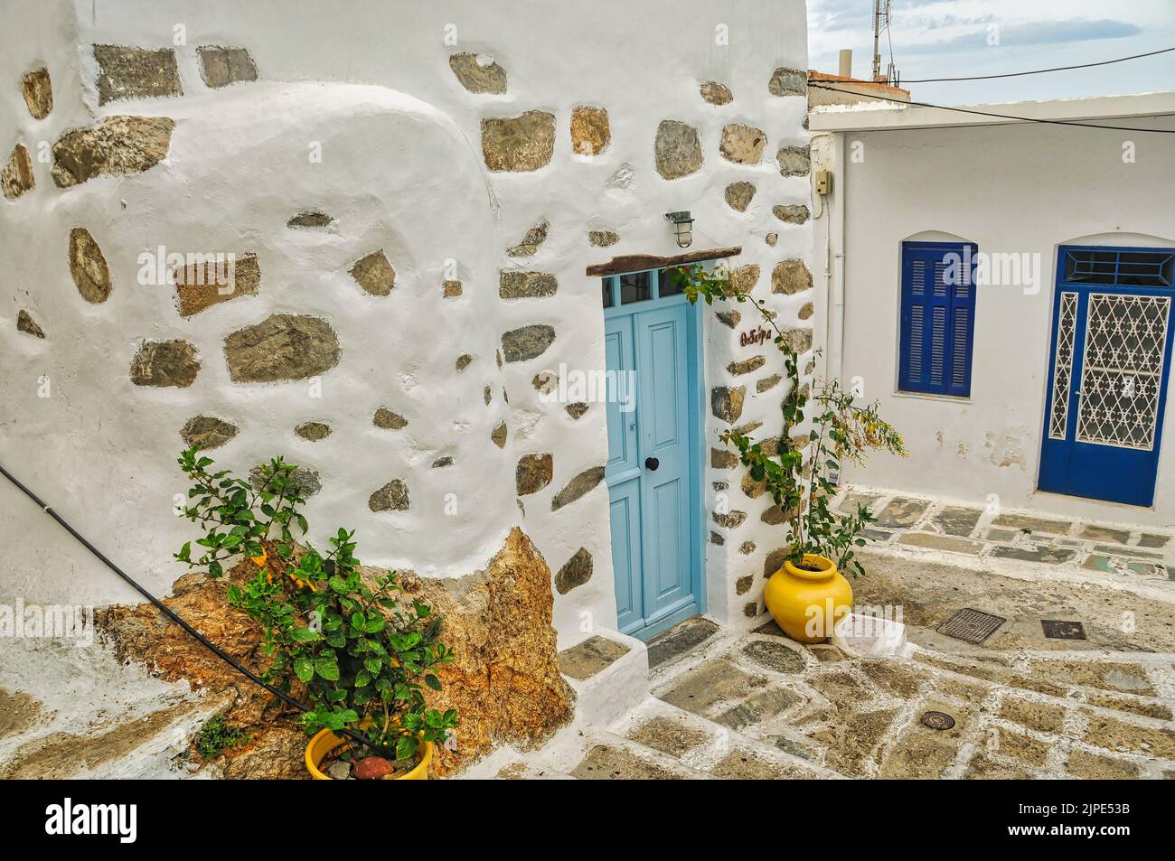 A Traditional white house exterior with a yellow flower pot in front