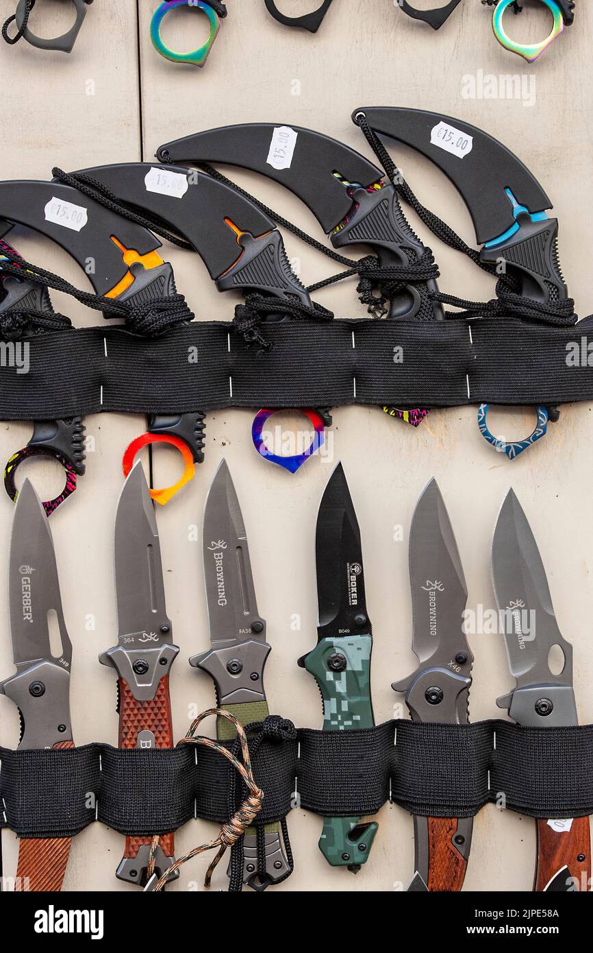 sharp knives on sale on a display board on the street in a tourists