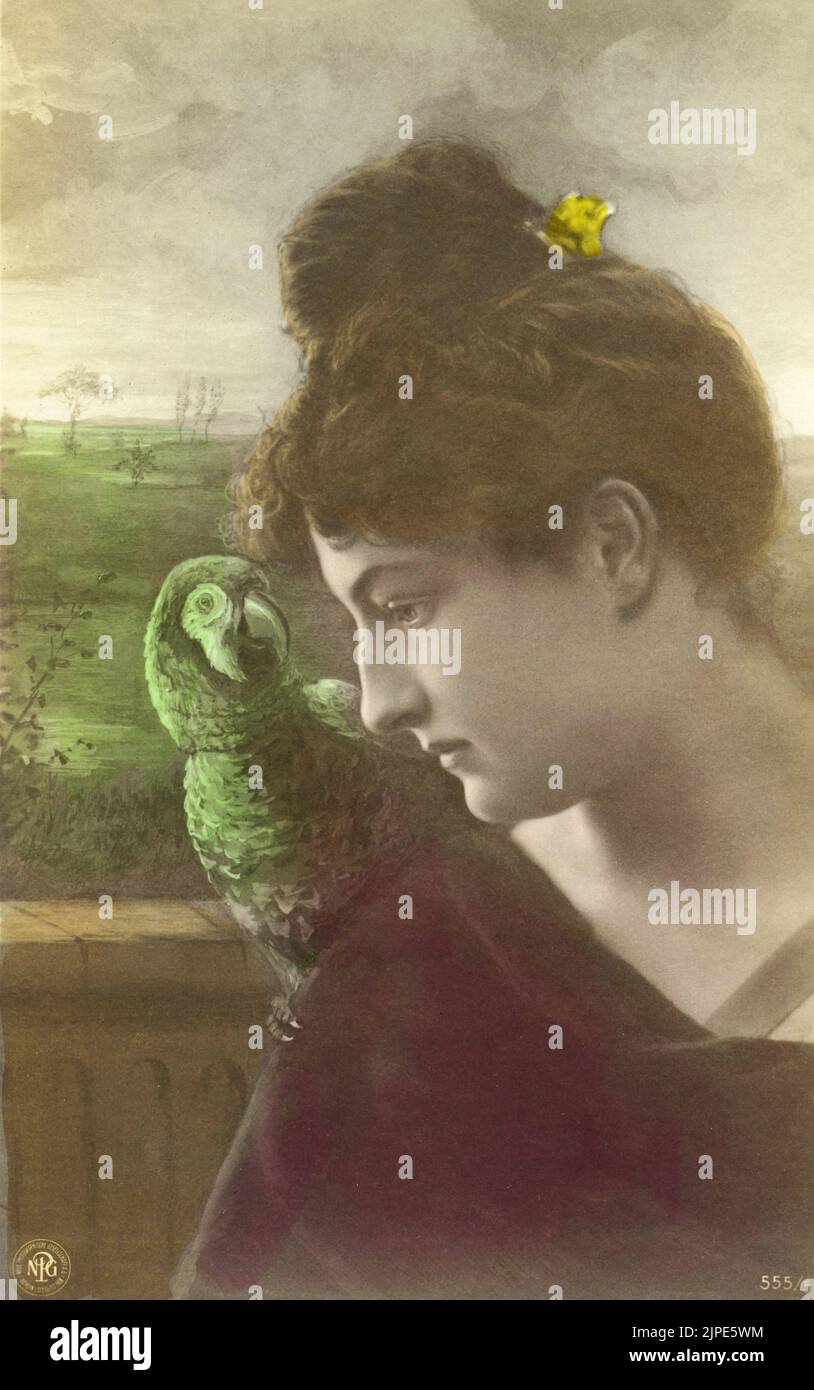 Early 20th century Victorian vintage postcard with colorized photographic portrait of a young woman in profile with a parrot sitting on her shoulder in a garden by A. G. Steglitz circa 1905 Stock Photo
