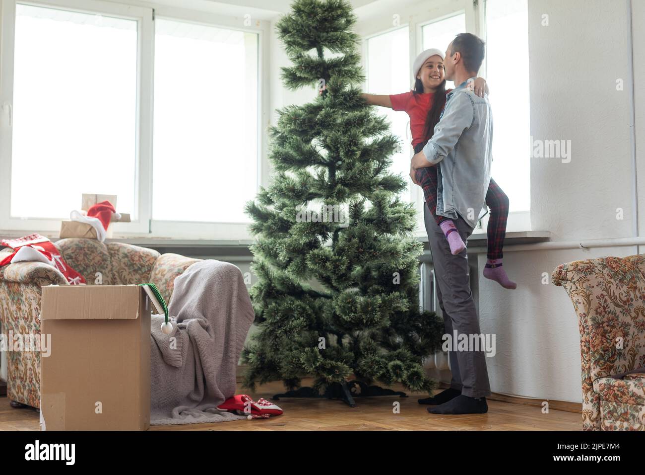 father and daughter install an artificial Christmas tree Stock Photo