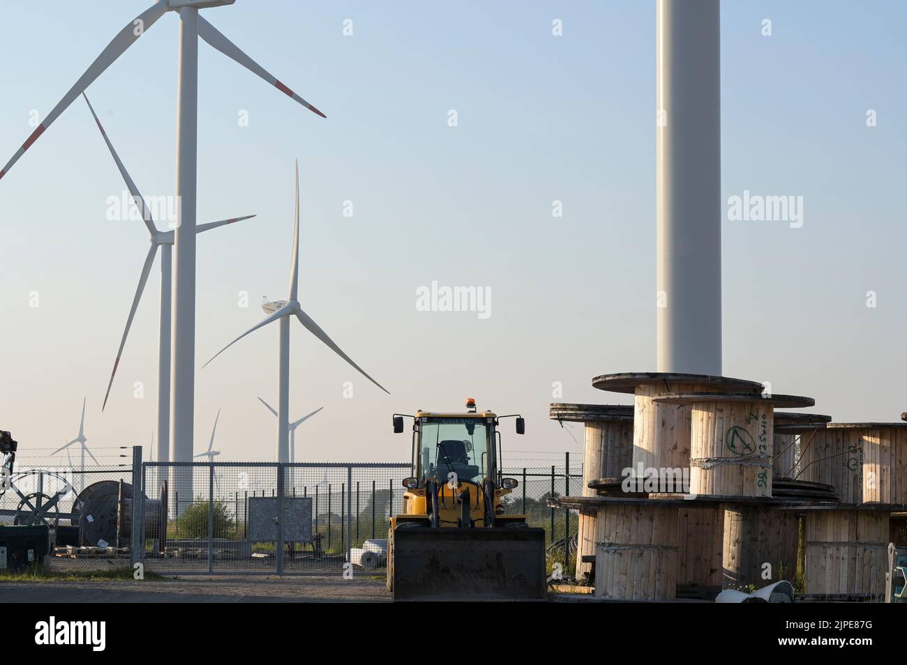 GERMANY, windenergy, windfarms with windturbine, wooden cable drum for grid installations / DEUTSCHLAND, Schleswig-Holstein, Reußenkoog, Windkraftanlagen Stock Photo