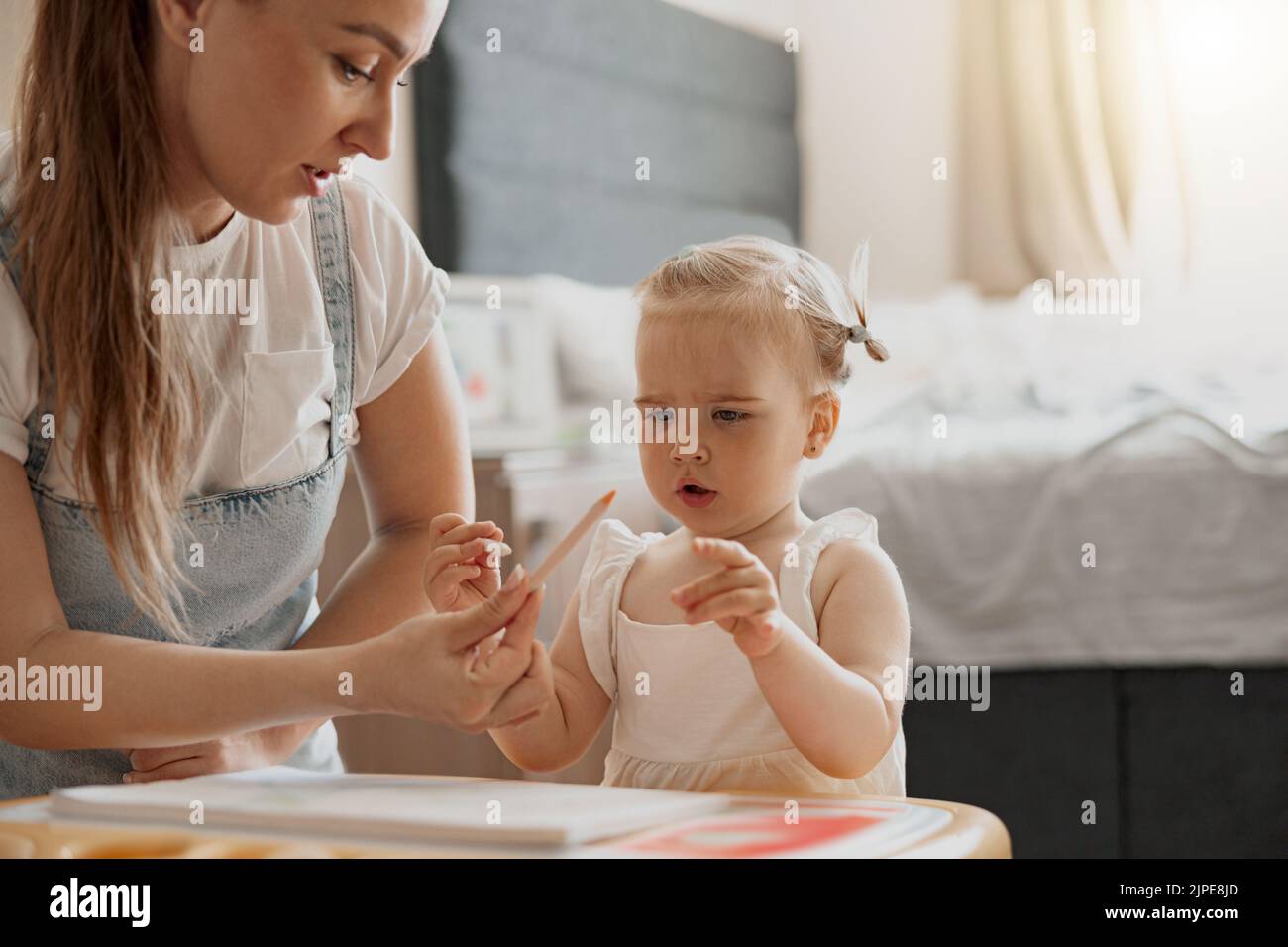 Little smiling girl painting with her mother at home while spending ...