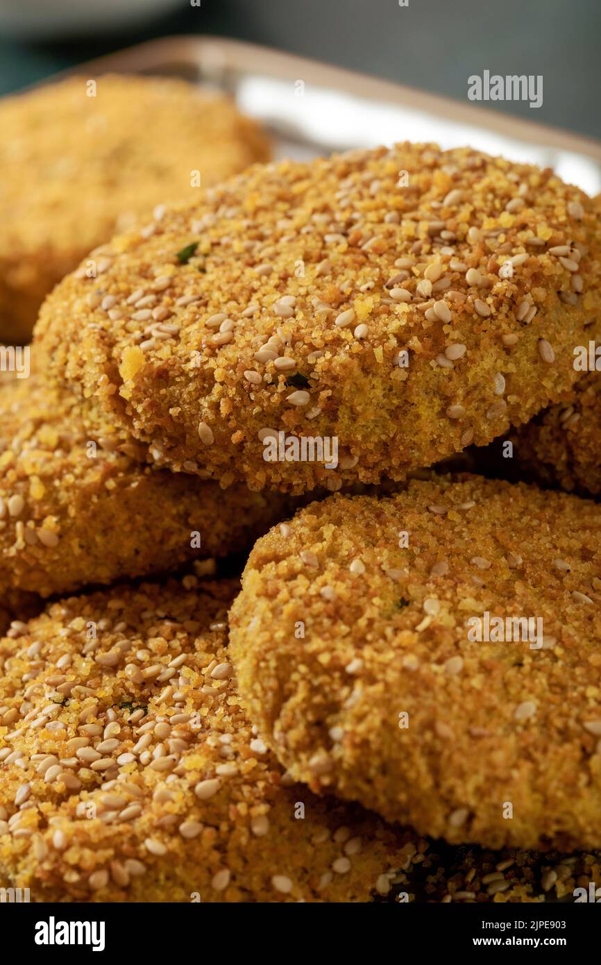 Macro close up of nuggets (croquettes) with gluten free bread crumb, sesame seeds and parsley. Stock Photo
