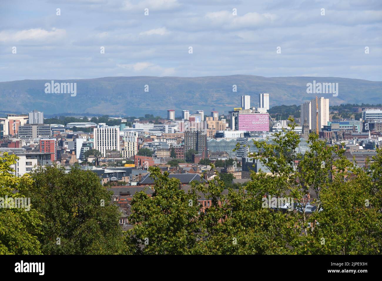 Glasgow, Scotland, UK. 17th, August, 2022. Glasgow weather. Warm sunshine replaced the rain of the last few days. A view of Glasgow city centre's iconic pink 'People Make Glasgow' sign and the Campsie hills in the background.  Credit. Douglas Carr/Alamy Live News Stock Photo