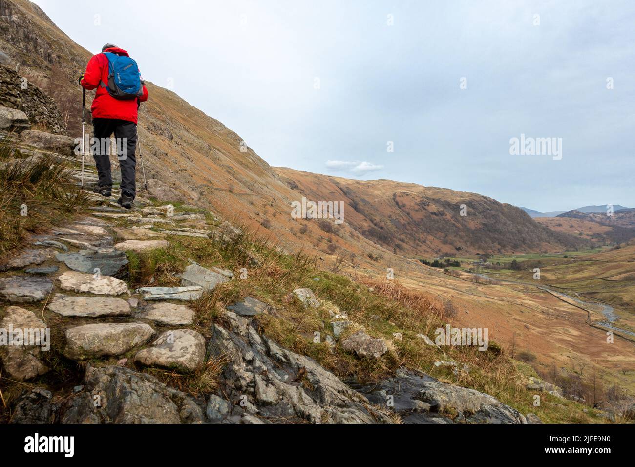 Hiker walking up a mountain path towards Styhead Tarn in Borrowdale, Lake District National Park, Cumbria Stock Photo