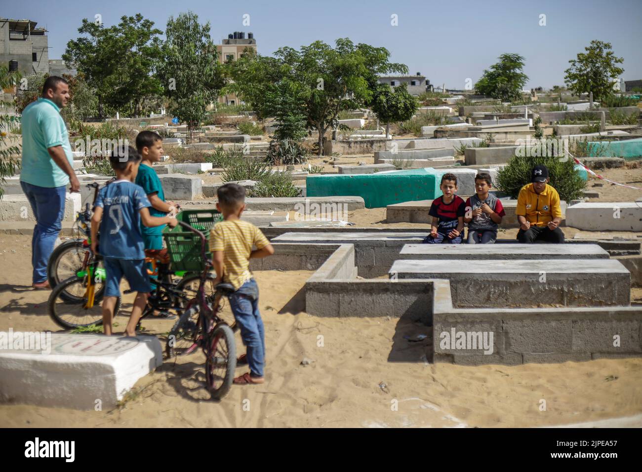 Relatives of five Palestinian children killed during the recent fighting between Israel and Gaza gather near their graves, in Jabalia in the northern Gaza Strip. Israel has admitted to killing five Palestinian children in an air raid on the Fallujah cemetery in the town of Jabalia, in the northern Gaza Strip, on August 7th, after initially claiming they were killed as a result of a missile fired by Islamic Jihad, Israel's Haaretz newspaper reported. Stock Photo