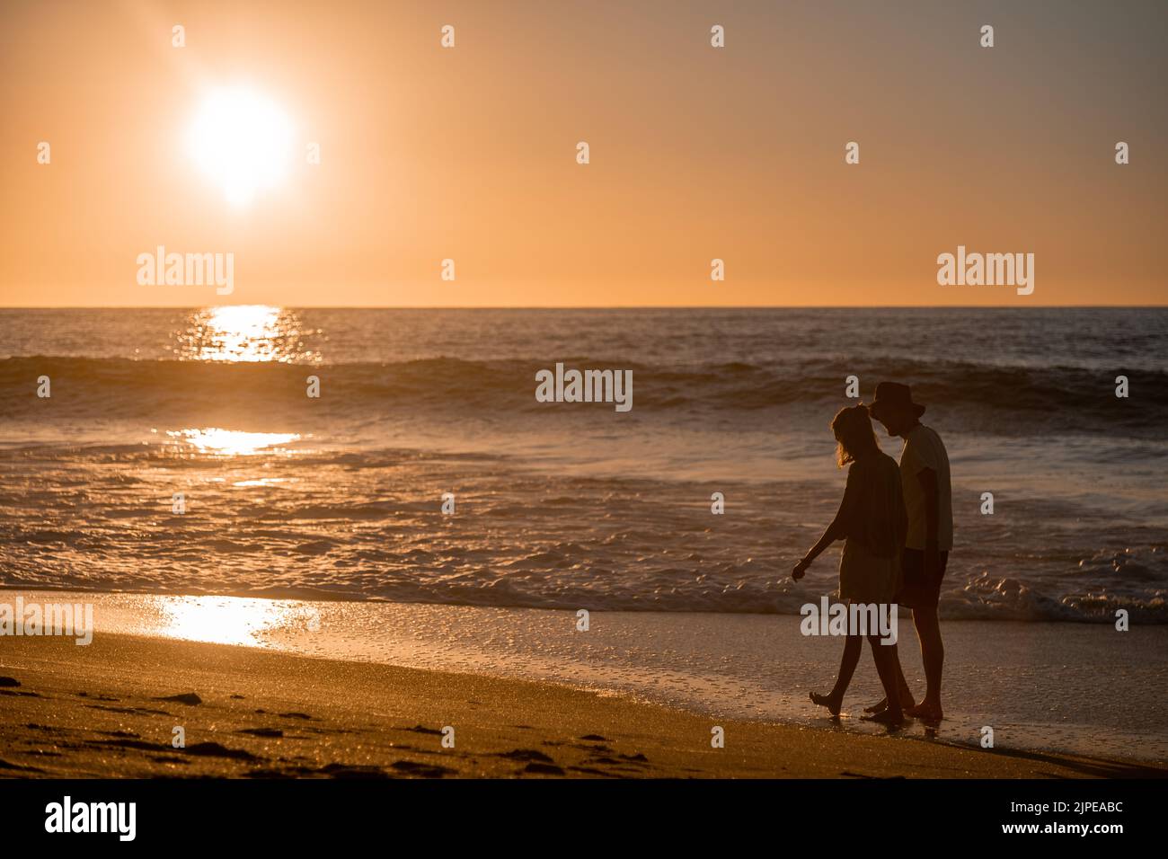Pareja romántica caminando por la playa al atardecer en Sayulita México