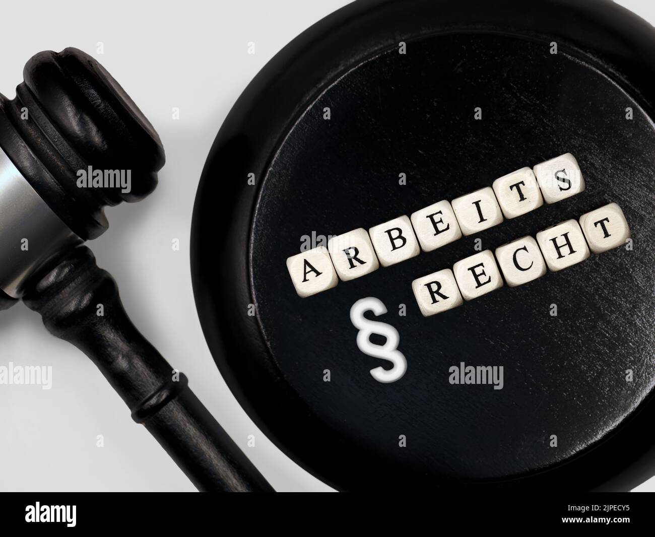Judge gavel with round block and the german word Arbeitsrecht for labor law or employment law with paragraph symbol Stock Photo