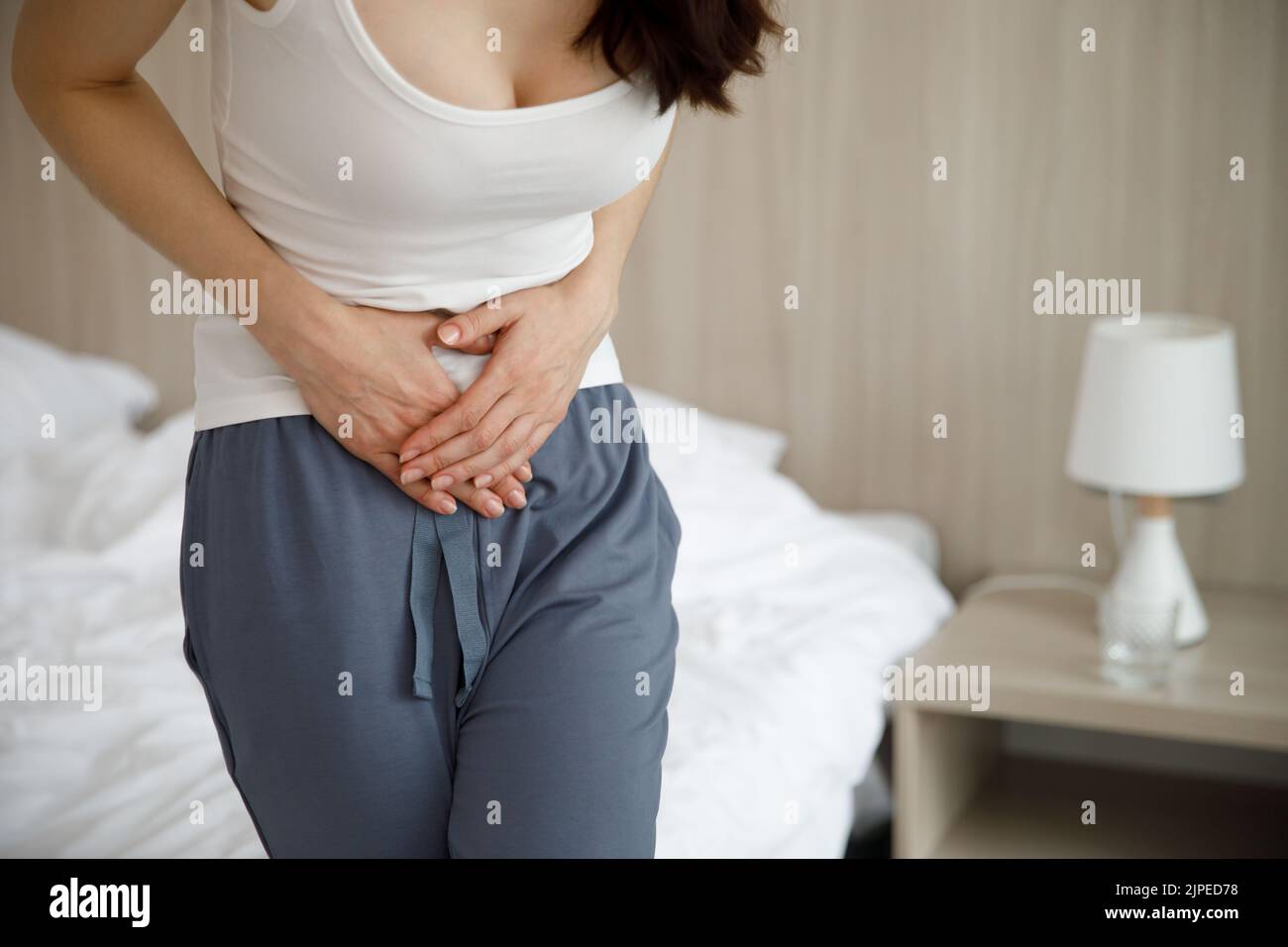 The woman is suffering from abdominal pain. Symptoms of cystitis. Stock Photo