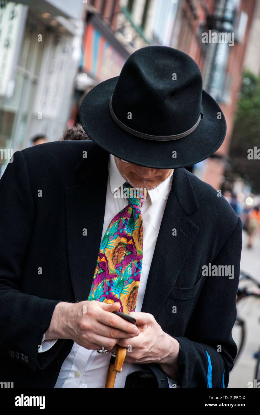 Man wearing 1930s style fedora hat and pin-stripe suit with a wide and colorful tie, New York City, NY, USA Stock Photo