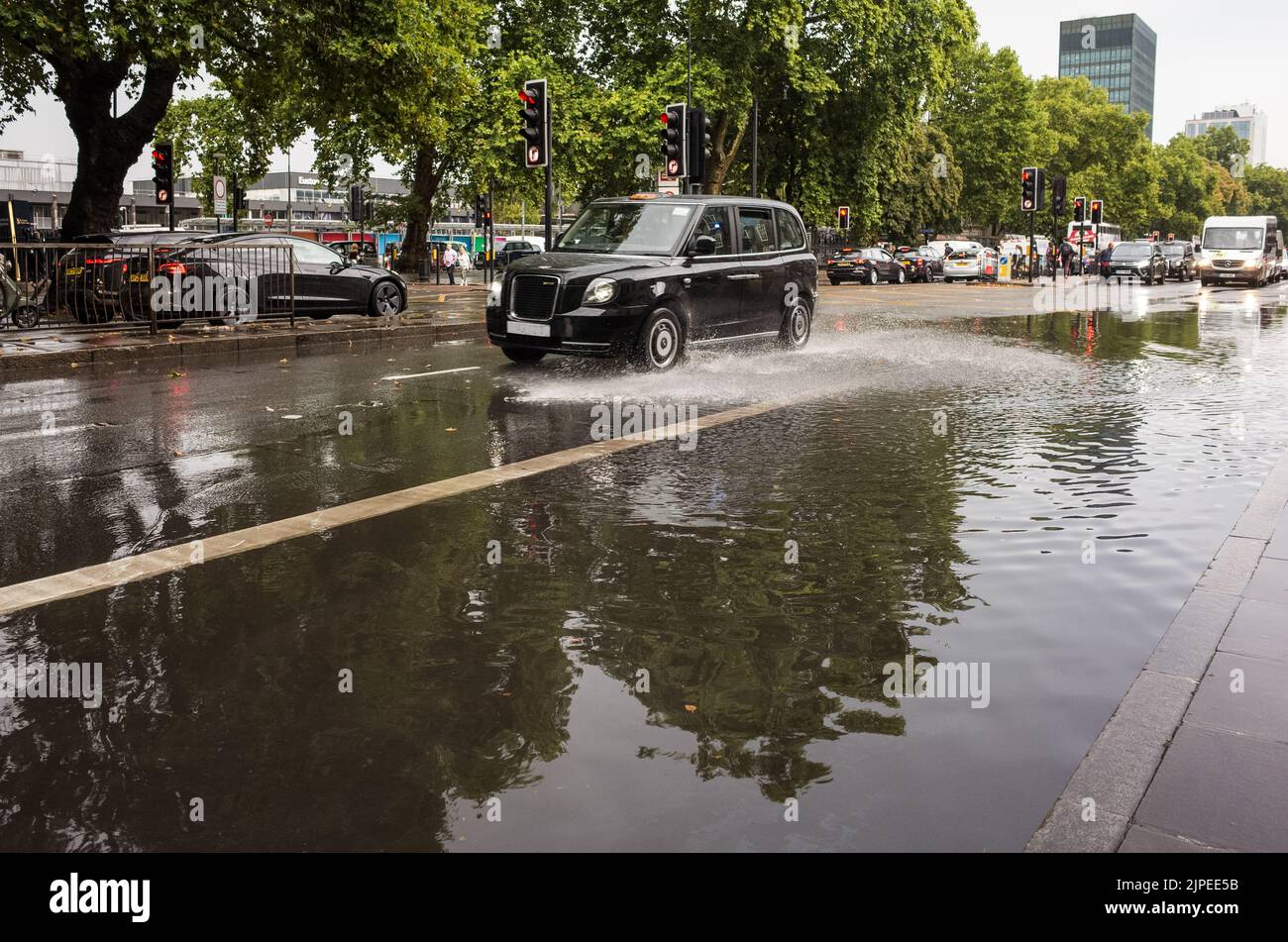 Car drives through flooded Euston Road in Central London after rain storm, England, UK, British Weather. Stock Photo