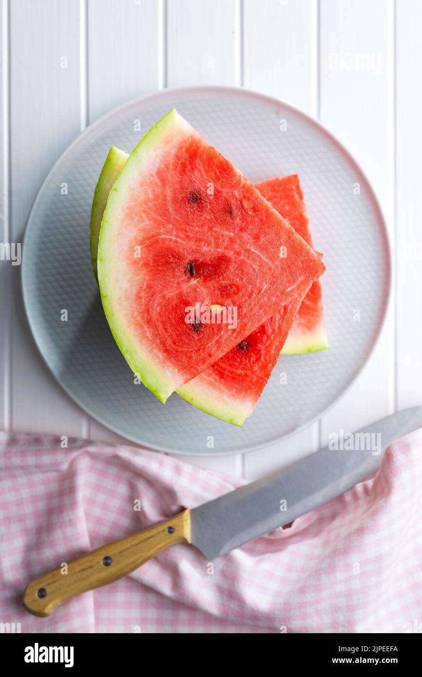 Slices of red watermelon on a plate. Top view. Stock Photo